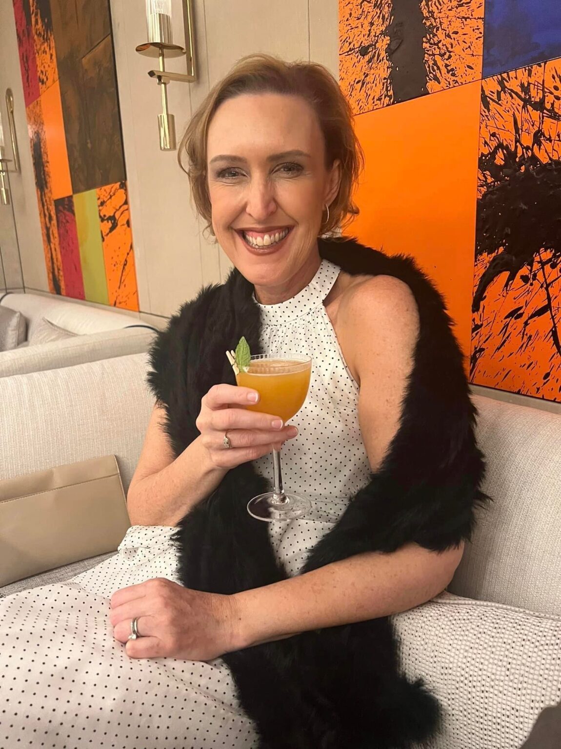 Dr Liesel Ryan smiling with a cocktail at a lounge